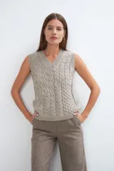 Chaleco de lana color crudo, tejido con escote en V y diseño con diferentes puntos combinados en el frente.