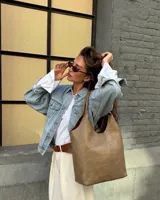 Cartera tipo tote de eco cuero color visón con diseño estructurado y asas largas para el hombro.