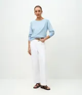 Suéter de punto color marrón chocolate, con cuello redondo y mangas largas con puños acanalados. Presenta un diseño básico y versátil de corte recto.