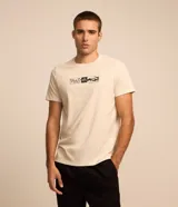 Remera color crema de corte regular, con cuello redondo y mangas cortas. Presenta un estampado rectangular en el pecho con elementos de la naturaleza en blanco y negro.