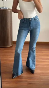 Jean de denim azul de tiro medio, corte semi oxford con botamanga deshilachada.