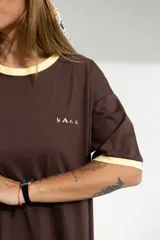 Vestido largo marrón con cuello redondo y mangas cortas con ribete amarillo. Estampado frontal con letras en color crema.