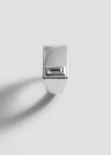 Anillo de zinc color plateado con diseño geométrico y aplicación de cristal tallado en corte baguette.