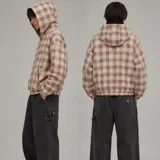 Campera con capucha y cierre frontal completo, con diseño a cuadros en tonos beige y bordó, bolsillos frontales tipo canguro y elástico en puños y cintura.
