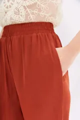 Pantalón palazzo tiro alto color terracota, con cintura elastizada y bolsillos diagonales. Corte relajado y largo al tobillo.