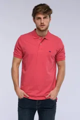 Remera polo de piqué color salmón, con cuello tejido en rib, cierre frontal de dos botones y pequeño bordado contrastante en el pecho.
