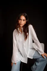 Camisa rosada con detalles de broderie en la parte delantera y mangas anchas.