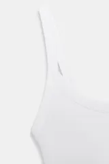 Body de cuello cuadrado con tirantes finos, confeccionado en tejido elástico con cierre inferior mediante botones a presión.