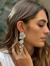 Aros largos plateados con diseño floral colgante.