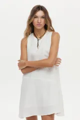 Vestido corto de lino blanco, sin mangas, con cuello redondo y diseño holgado.