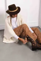 Bota de caña media-alta en cuero color óxido de acabado gastado, con hebillas de inspiración gótica y punta cuadrada bien marcada.