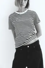 Remera de corte recto en punto suave de algodón con cuello redondo ribeteado y hombros ligeramente caídos. Diseño a rayas horizontales blancas y negras.