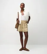 Short runner color beige de tiro medio, confeccionado en sarga de algodón. Cuenta con cintura elástica con lazo ajustable, bolsillos tipo carpintero en los laterales y diseño holgado.