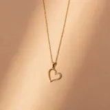 Conjunto de collar en oro 18k compuesto por una cadena fina de eslabones y un dije en forma de corazón con incrustaciones de circonias.