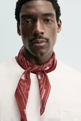 Pañuelo cuadrado (bandana) color bordó con estampado de corazones blancos y líneas curvas que forman un patrón de rejilla.