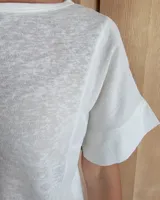 Remera blanca de corte holgado con cuello redondo y mangas cortas.