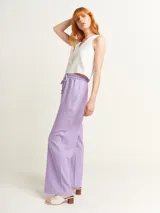 Pantalón de lino color lila, tiro alto, corte palazzo con elástico en la pretina, bolsillos laterales y dobladillo invisible.