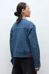 Chaqueta de jean de lavado medio, corte holgado, con cuello y puños de tela estampada a cuadros vichy en blanco y negro.