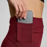 Calza larga de running Saucony Fortify, color bordó, de tiro alto y calce ajustado. Cuenta con bolsillo con cremallera en el muslo y en la parte trasera.