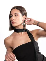 Corbatín negro de tela brillante y textura fina, diseñado para llevar atado al cuello como accesorio elegante.