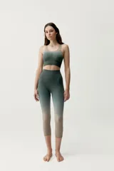 Calza deportiva corta de diseño seamless, con efecto degradado que transiciona del gris azulado en la parte superior al marrón en las piernas.