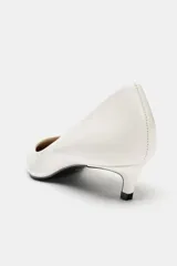 Zapato de tacón kitten fino en piel, color blanco, con escote redondo y acabado en punta.