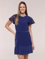 Vestido corto azul de seda fría elastizada, con mangas cortas de encaje calado, lazo para ajustar en la cintura y ruedo con volado plisado.