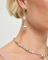 Aros colgantes de plata con diseño lineal que incorpora cristales facetados multicolor, una perla central y un dije de estrella en el extremo inferior.