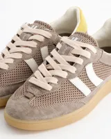 Championes Coolway modelo Baresi Urban Terra, inspirados en el fútbol indoor. Confeccionados en serraje y nylon efecto malla en tonos marrones, con bandas laterales blancas, detalle amarillo en el talón y suela de goma con amortiguación en gel.