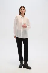 Camisa celeste de lyocell con textura arrugada, corte holgado, cuello clásico y cierre frontal con botones.