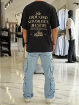 Remera oversize blanca de manga corta, con gran estampado tipográfico en color rojo en la espalda con la leyenda "The Grounded Automotive Lifestyle".