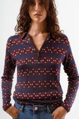 Camiseta de manga larga con cuello polo y cierre frontal parcial, confeccionada en tejido de punto con estampado geométrico en tonos azul, bordó y celeste.