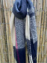 Bufanda larga con flecos, diseño a cuadros en tonos amarillos, naranjas, azules y celestes.