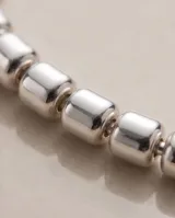 Pulsera de plata 925 compuesta por pequeños cubos facetados en hilo de plata y cadena de alargue finalizada en dije colgante.