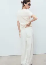 Cardigan de punto de algodón con cuello redondo, manga corta y cierre frontal con botones.