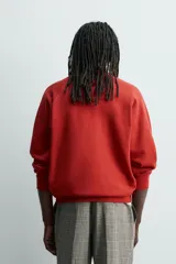Sudadera de corte relajado con efecto lavado, confeccionada en algodón con interior de rizo. Presenta cuello redondo, manga larga raglán y acabados en rib.