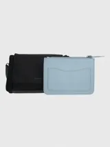 Cartera tipo bandolera Hush Puppies de color negro, con solapa frontal y cierre. Presenta una correa ajustable con el logo de la marca y detalles metálicos.