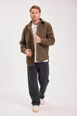 Campera marrón de borreguito con cuello camisero, cierre con botones a presión y bolsillo de parche en el pecho.
