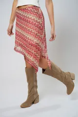 Minifalda asimétrica de crochet con diseño de ondas en tonos rojo, rosa y beige.