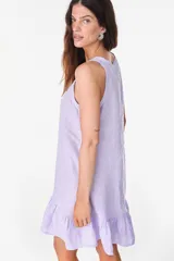 Vestido corto lila de lino, sin mangas, con escote redondo, cartera de botones de nácar en el frente y volado fruncido en el ruedo.