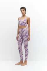 Calza deportiva de tiro alto con estampado tie-dye en tonos violeta y lila, confeccionada en tejido elástico y transpirable.