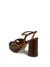 Sandalias de cuero charolado color peltre, con plataforma de madera y taco cuadrado.