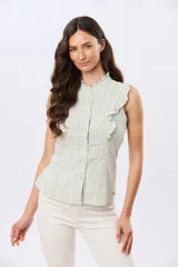 Camisa musculosa de lino y algodón con diseño de rayas verticales blancas y verdes. Cuenta con cuello mao con volados, detalles de volados en los hombros y cierre frontal con botones.