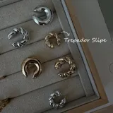 Set de aros trepadores tipo ear cuff, en metal dorado y plateado, con diseño liso y trenzado.
