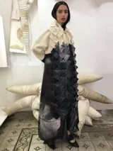 Tapado largo de lana merino afieltrada, color natural combinado con gris, con textura "cubo" en el frente.