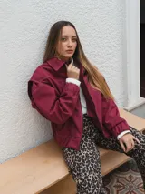 Campera bomber color borgoña con costuras en contraste color blanco.