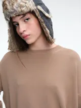 Sweater de punto color negro, con cuello redondo, hombros caídos y terminaciones acanaladas en puños y ruedo. Presenta un diseño de calce relajado y tejido suave.