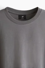 Remera de algodón liviano color gris, con cuello redondo y mangas cortas, de corte estándar y diseño liso.