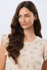 Remera blanca de algodón con delicado estampado floral y volados en las mangas cortas, con diseño de cuello redondo.
