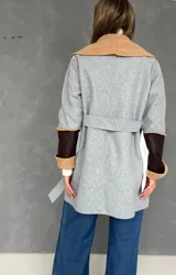 Saco de paño gris con solapas amplias de corderito color tostado. Presenta detalles de parches en cuero sintético marrón en las mangas y puños con vuelta de corderito.